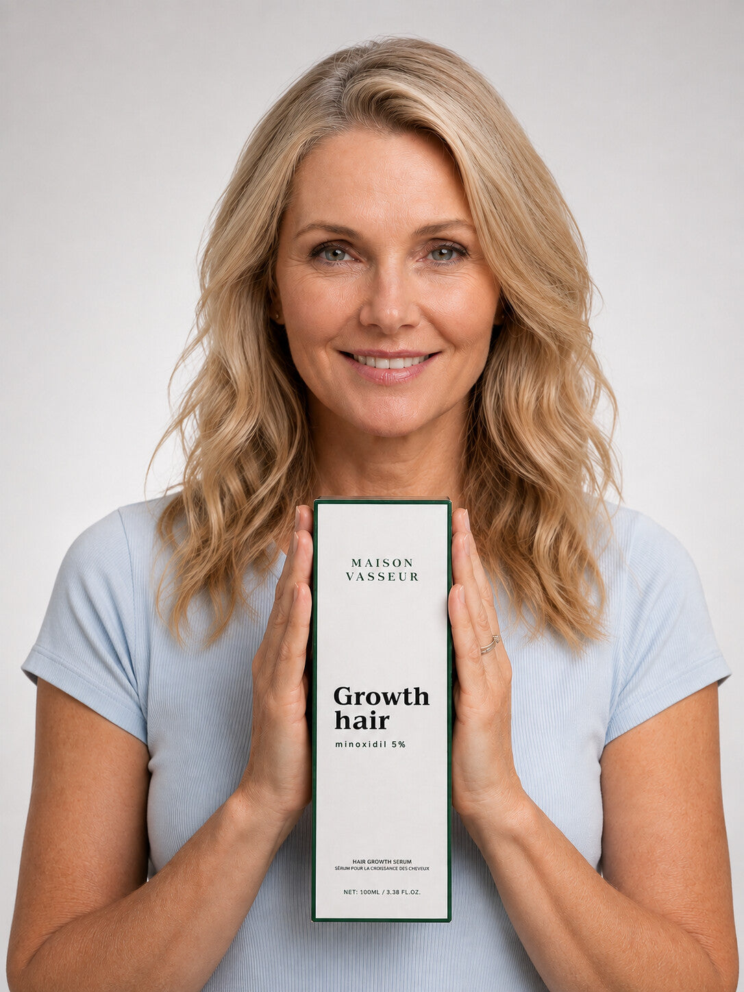 Woman holding Maison Vasseur hair growth serum box